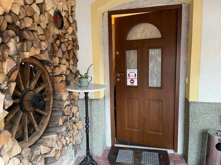 Eingangstür der Pension Mariba mit Natursteinwand