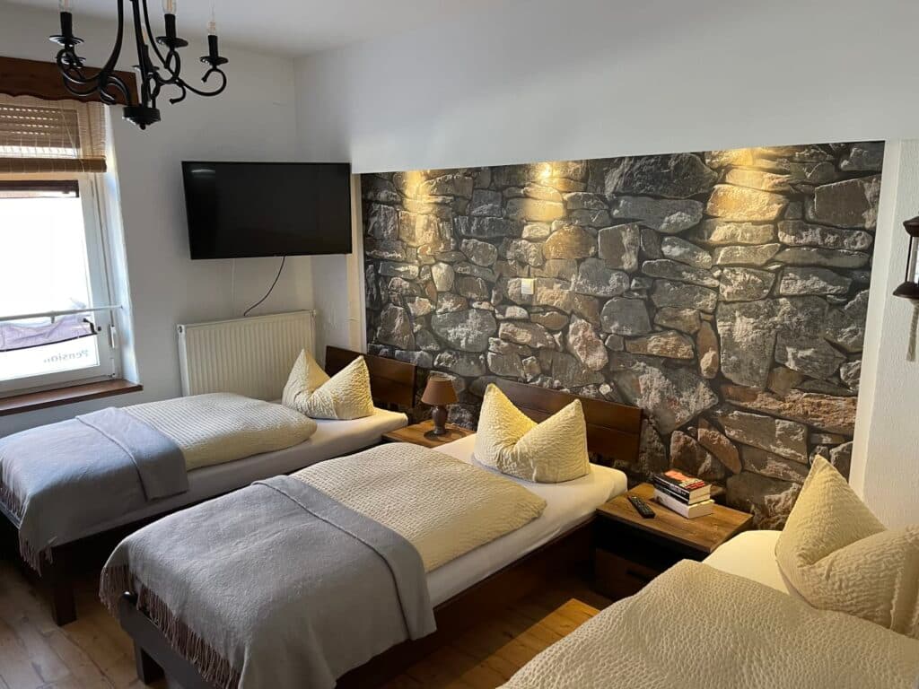 Familienzimmer mit drei Betten und Steinwand-Optik